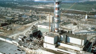 The damaged Chernobyl nuclear power plant: a group of ruined and damaged gray, green and white buildings