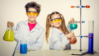 Best science kits for kids - Two cute children at chemistry lesson making experiments on white background.
